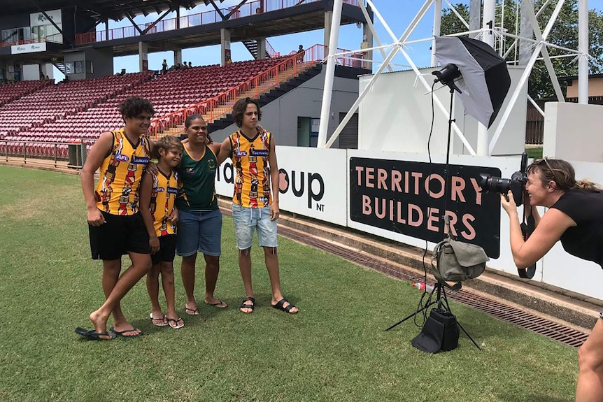 A photo of Lulu's family being photographed wearing her guernsey design.