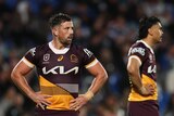 Brisbane Broncos player Tyson Smoothy stands on the field during an NRL game with his hands on his hips.