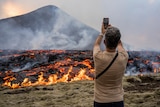 Man stands with phone in front of erupting Iceland volcano 
