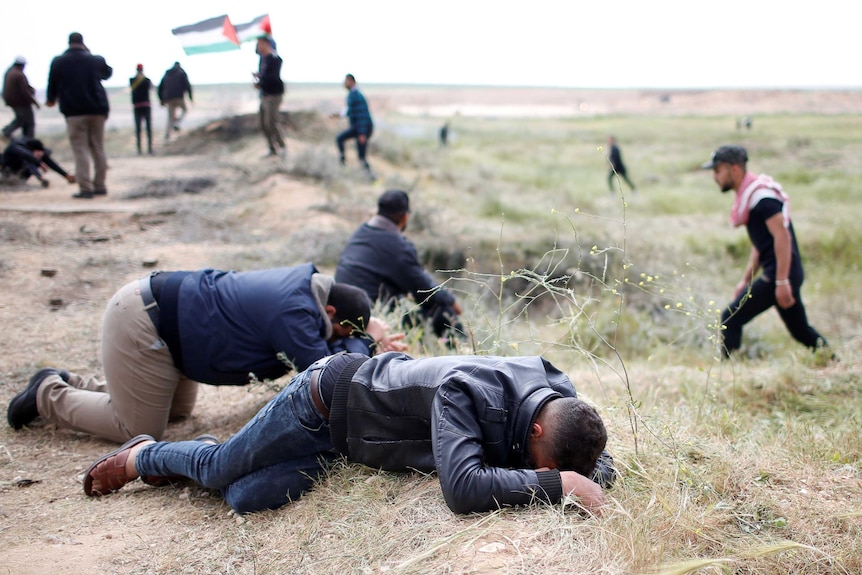 Palestinians react from tear gas fired by Israeli troops during clashes along the Israel border with Gaza.