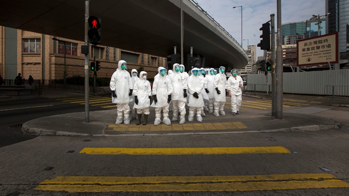 Health officials outside a poultry market in Hong Kong after and earlier case of H7N0 bird flu