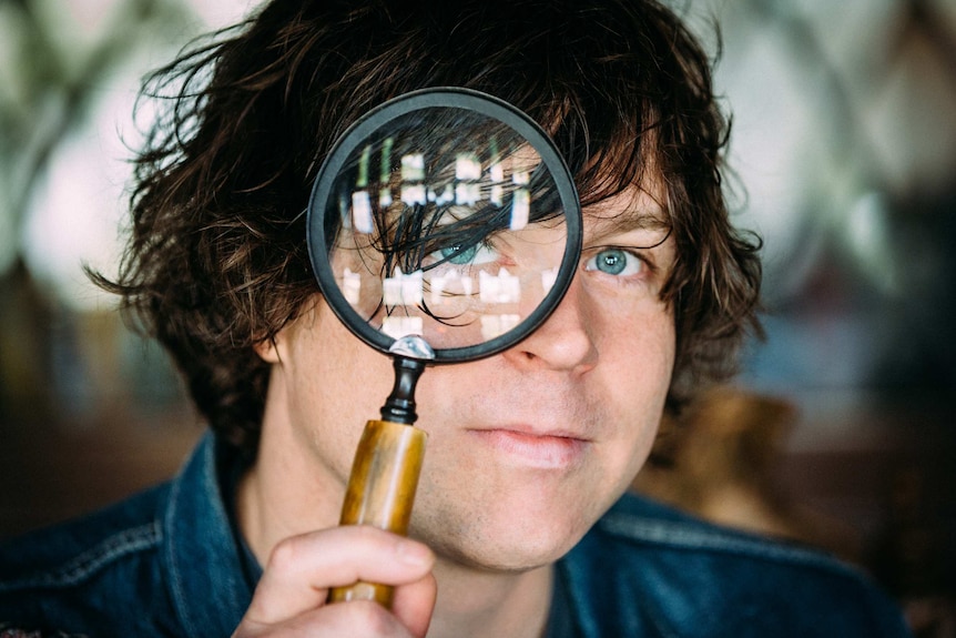 Ryan Adams looking through magnifying glass