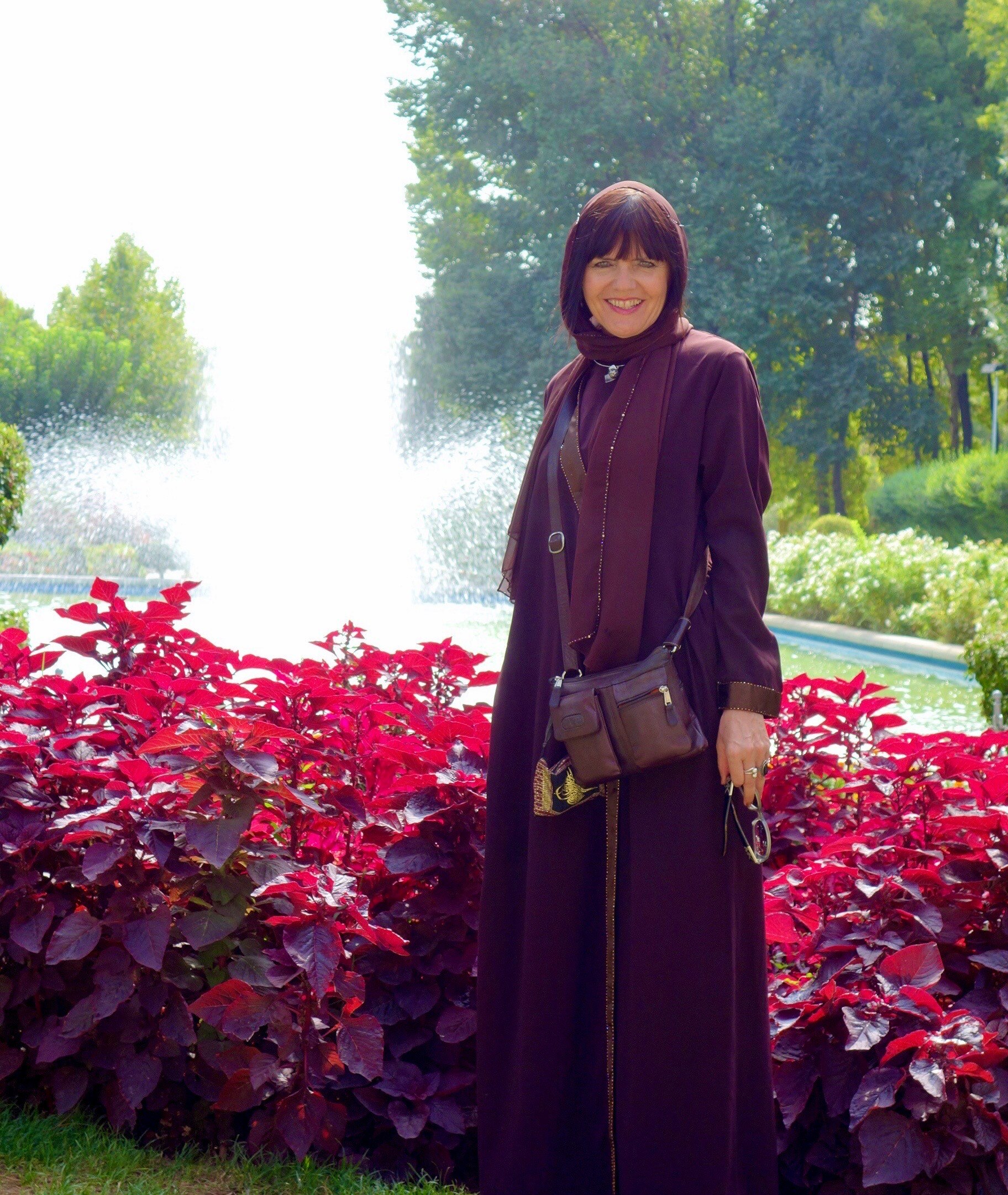 保琳·瑞安 (Pauline Ryan) 站在喷泉旁边。