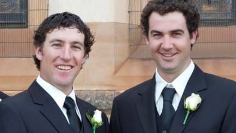 Nathan McPherson and Adam Symons stand in front of a church