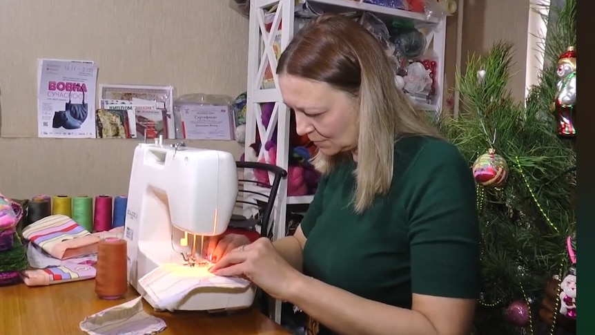 A woman working at a sewing machine at home