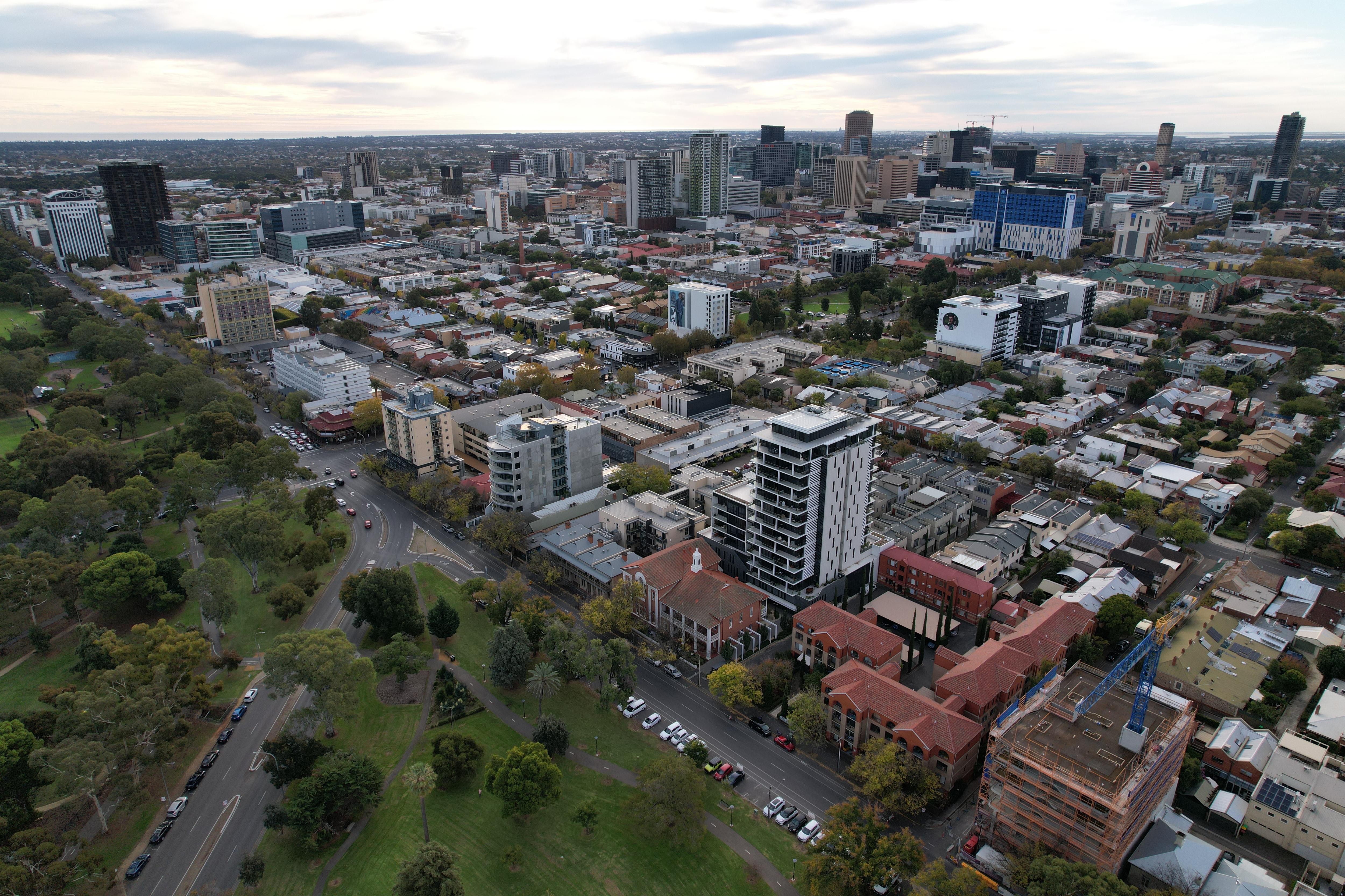 An aerial shot of Adelaide&#x27;s CBD buildings, with parklands in the left corner.