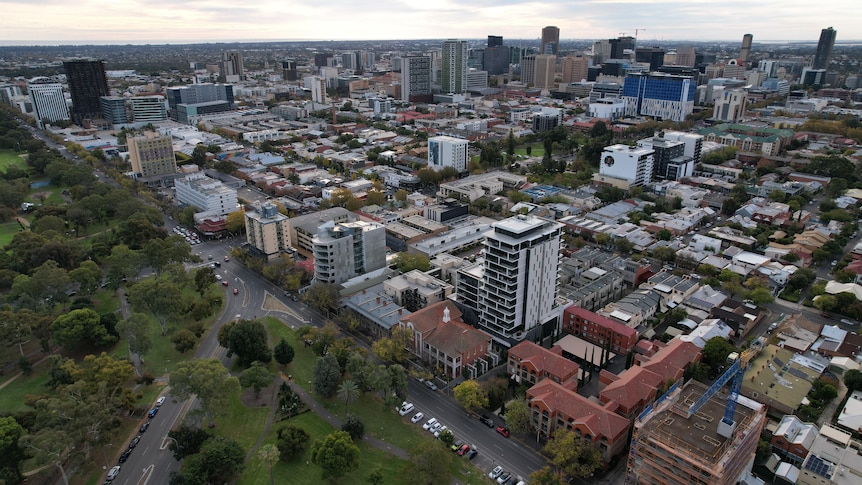 An aerial shot of Adelaide's CBD buildings, with parklands in the left corner.