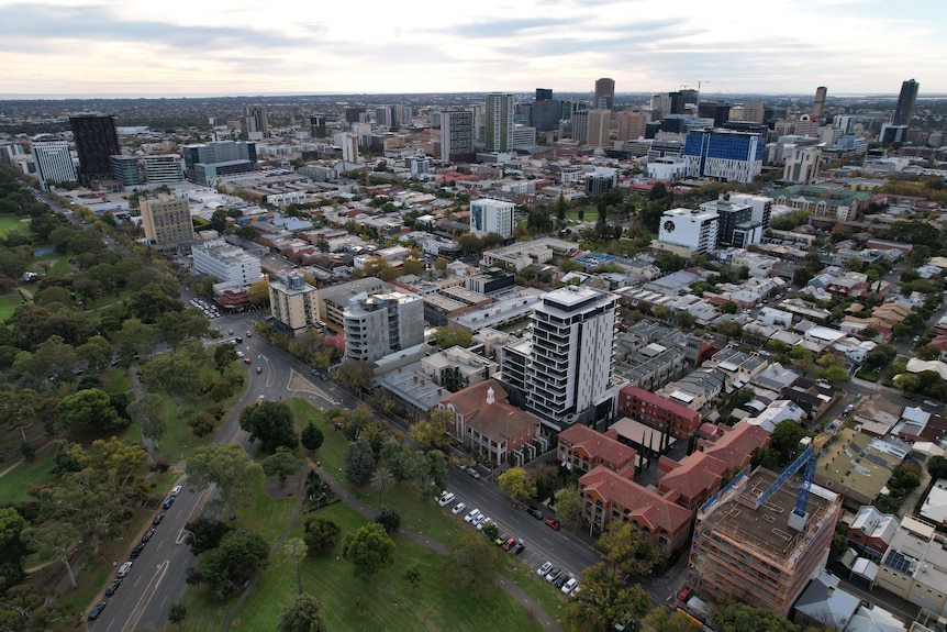 An aerial shot of Adelaide's CBD buildings, with parklands in the left corner.