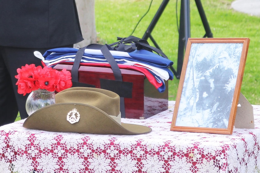 Paul Altimore standing at a lecturn delivering a speech next to table with photo of Private Halliday and other personal objects