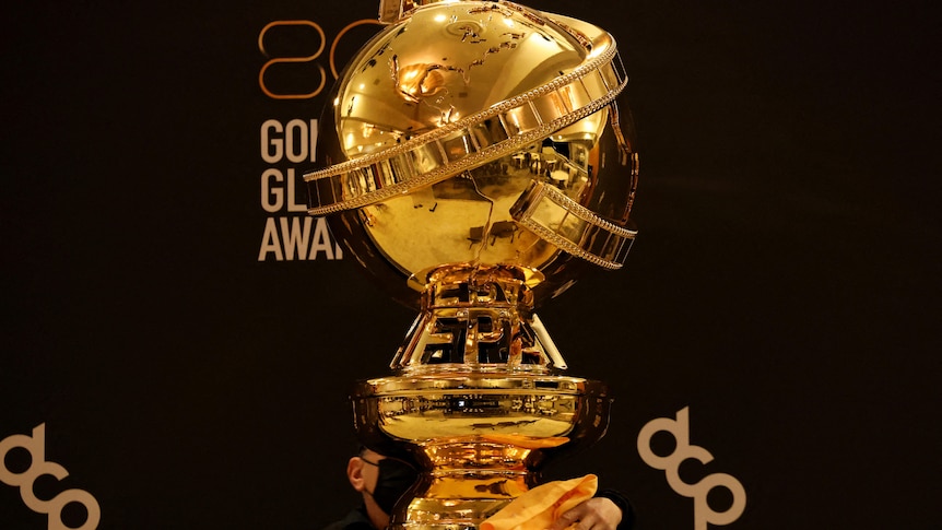A Golden Globe award, shaped like a globe on a pedestal with a strip of movie film wrapped around it.