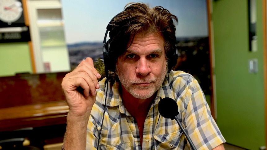 Tex Perkins in the ABC North Coast studio with headphones on.