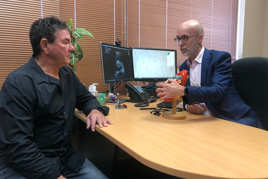 Doctor David Playford chats to patient Shane Caulfield in his office. 