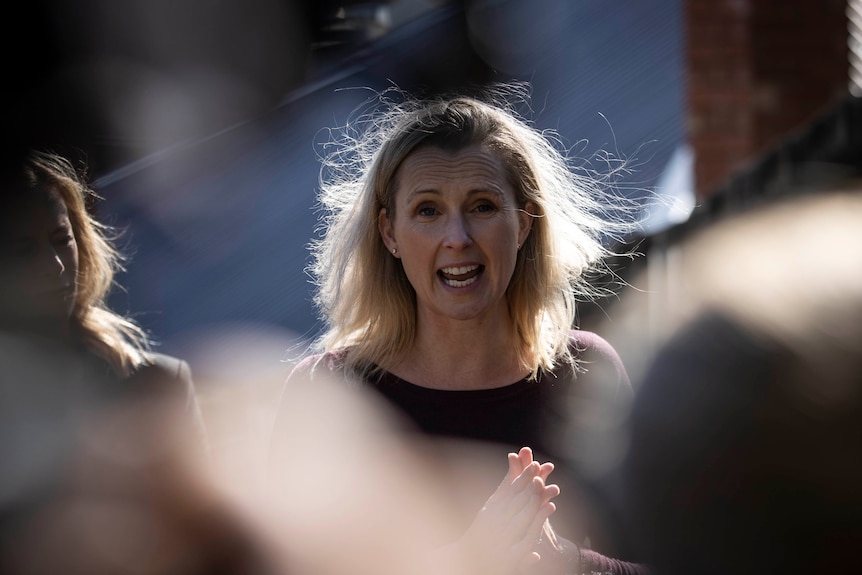 A woman talking in front of a crowd.