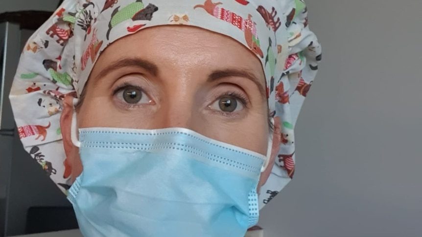 A woman wearing a surgical mask and cap.