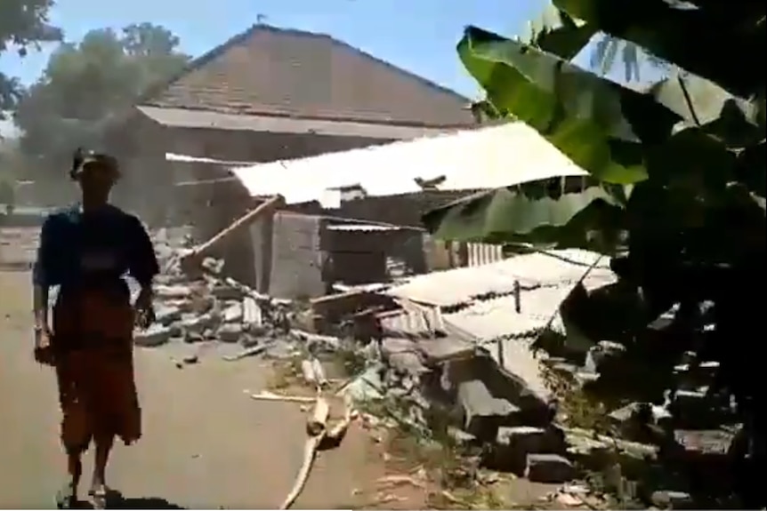 A man runs amid damaged buildings