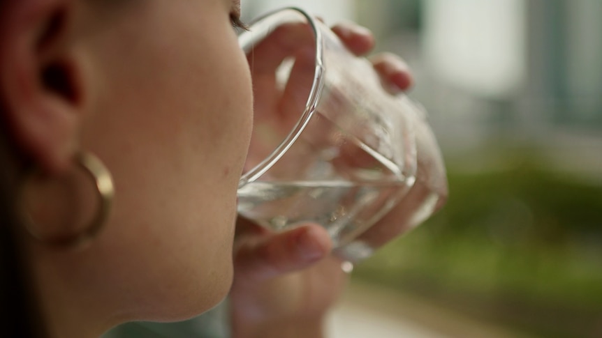 A person drinking water from a glass