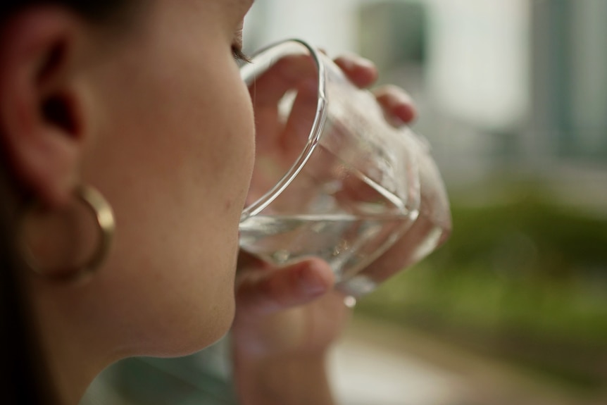 A person drinking water from a glass