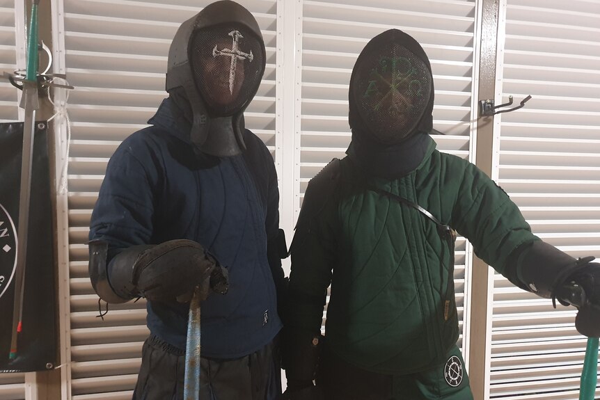 two men wearing fencing gear