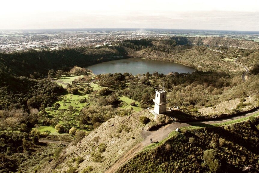 A scenery photo showing the tower's position surrounded by trees, hills and overlooking a lake.