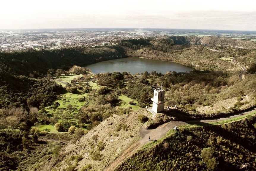 A scenery photo showing the tower's position surrounded by trees, hills and overlooking a lake.