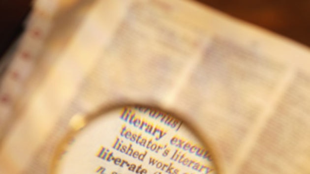 Magnifying glass enlarging words from dictionary