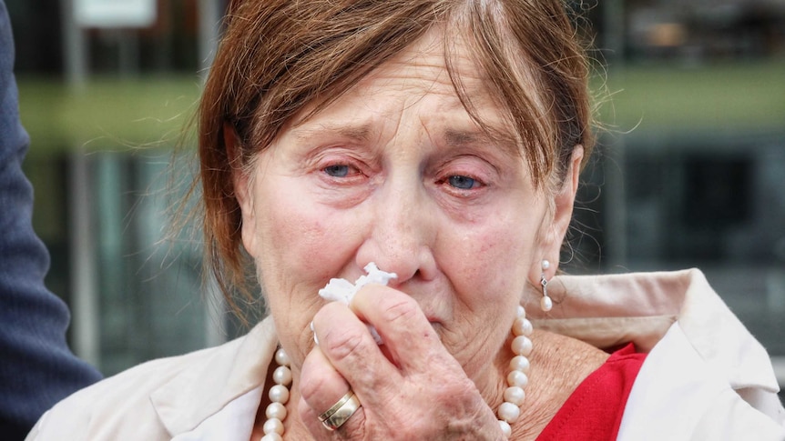 Shirley Stefaniak crying and holding a tissue to her face.