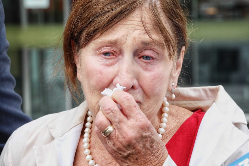 Shirley Stefaniak crying and holding a tissue to her face.