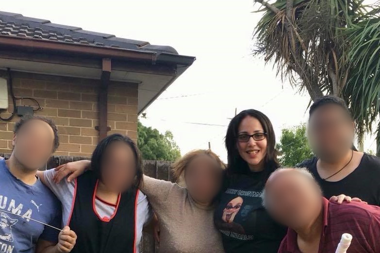 Lydia Abdelmalek poses in a suburban yard with her family.