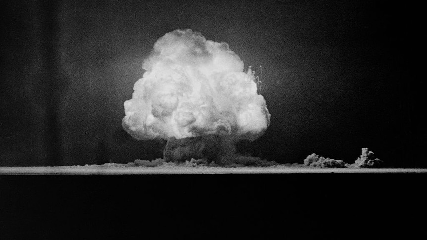 Black and white photo of the mushroom shaped cloud caused by the Trinity nuclear test