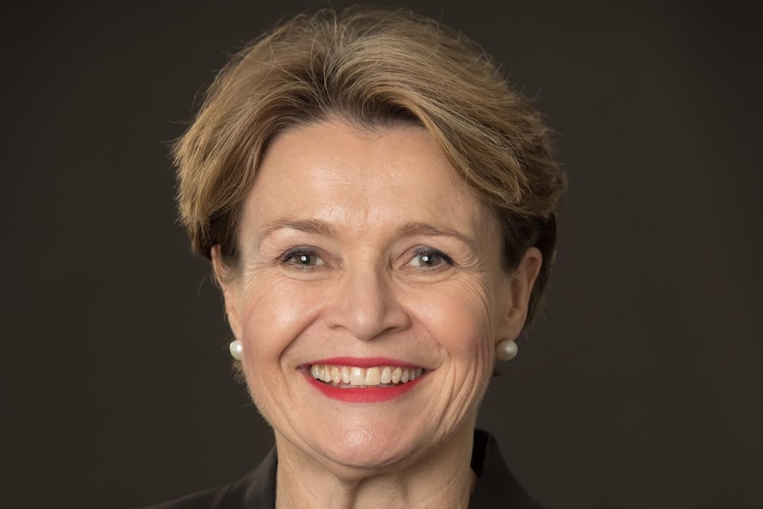 A woman with short hair smiling at the camera.