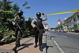 Officers patrol near the local police headquarters following an attack in Surabaya
