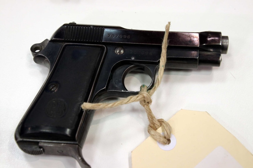 A Beretta snub pistol with string and a cardboard identification tag attached.