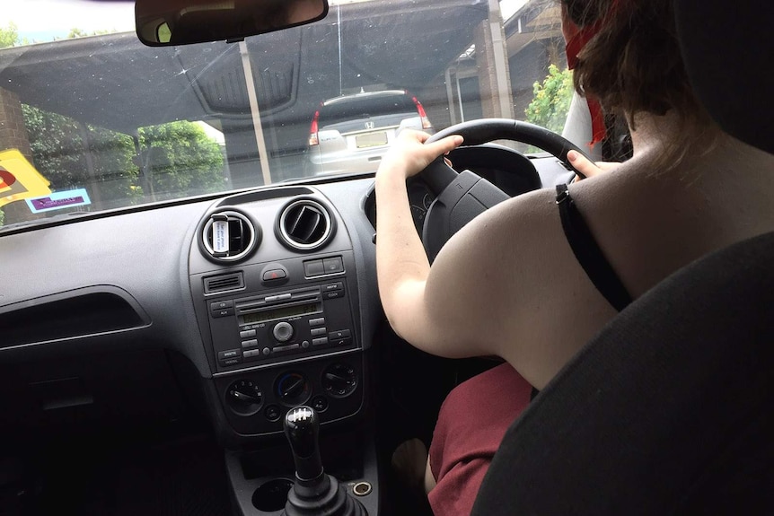 A young woman in the driver's seat of a car