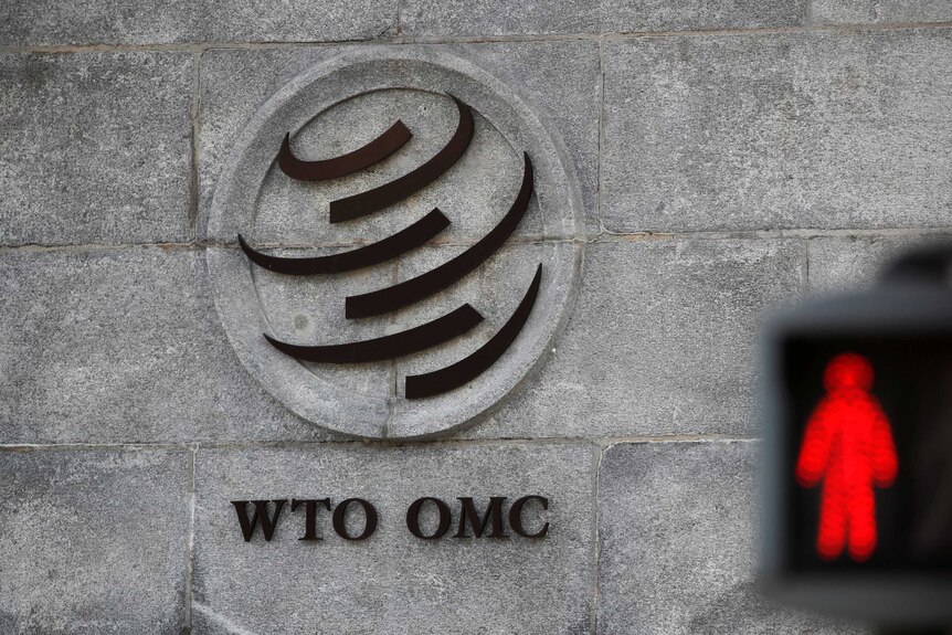 Un logo de l'OMC à côté d'un feu rouge.