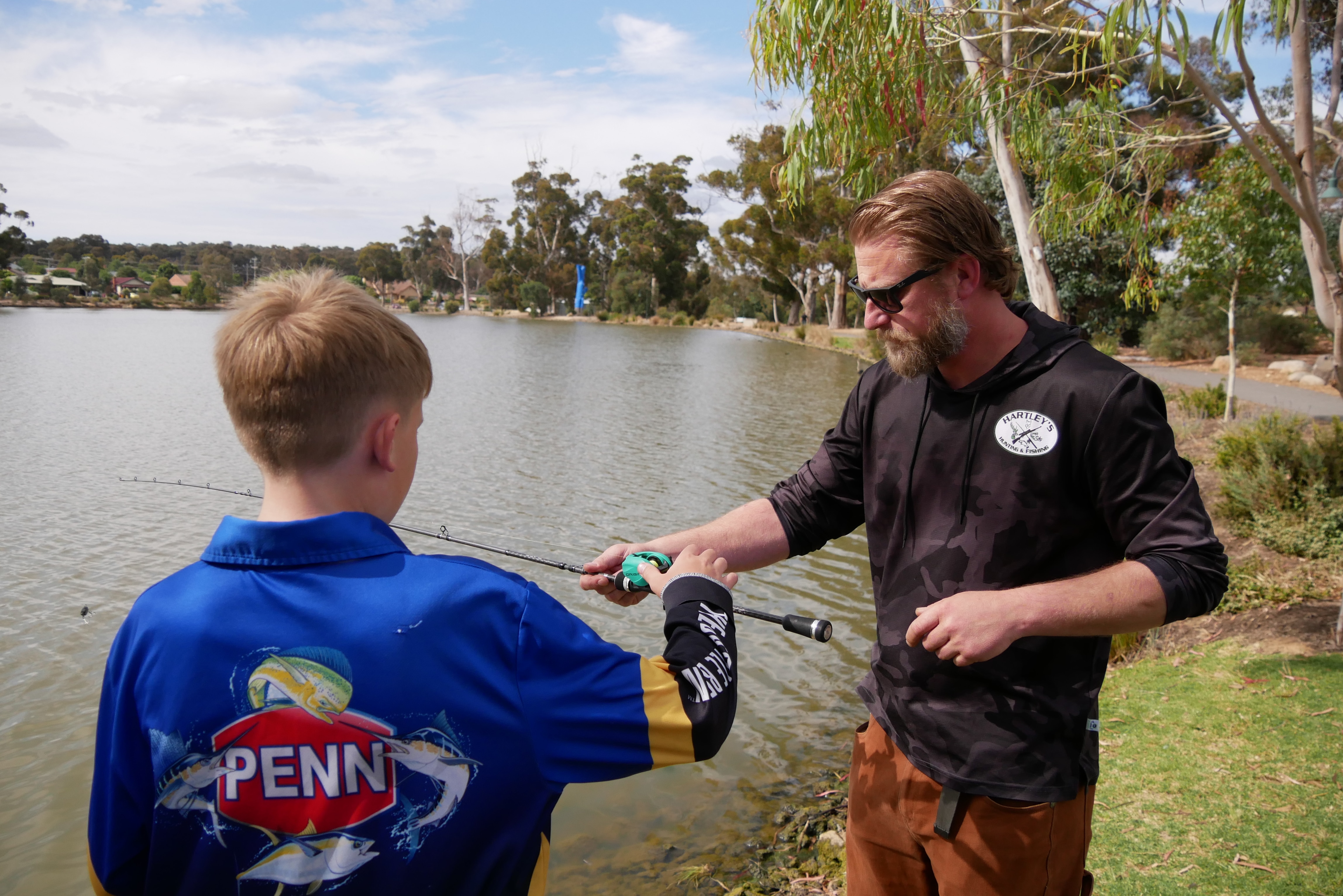 a man holds a fishing rod in front of a child