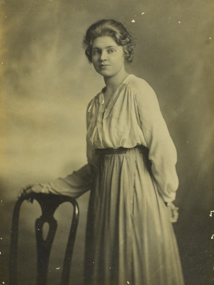 A sepia toned image of a young woman with dark hair pulled back. 