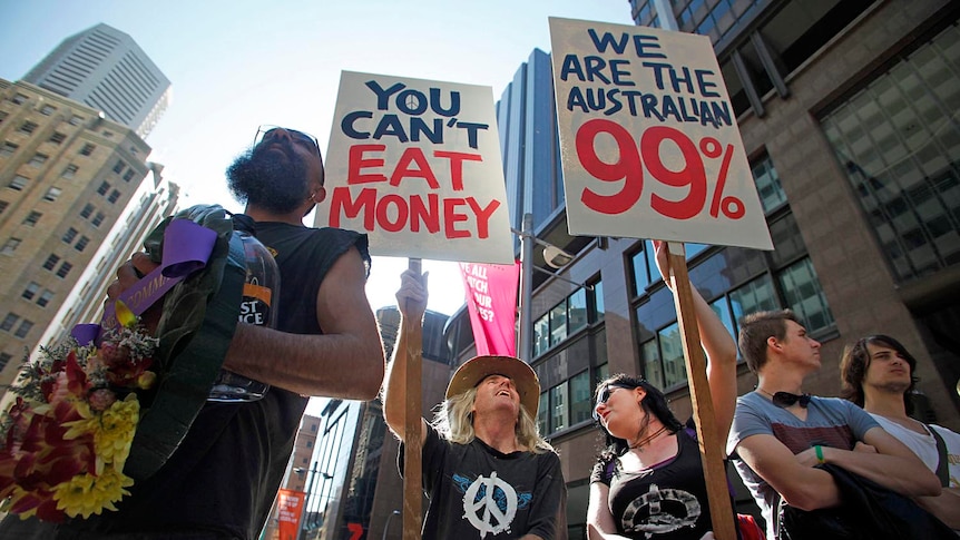 Protesters from the Occupy Sydney movement hold signs in front of the Reserve Bank of Australia in central Sydney.