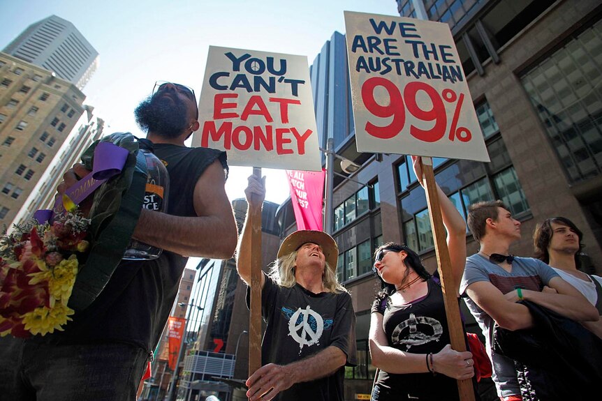 Protesters from the Occupy Sydney movement hold signs in front of the Reserve Bank of Australia in central Sydney.