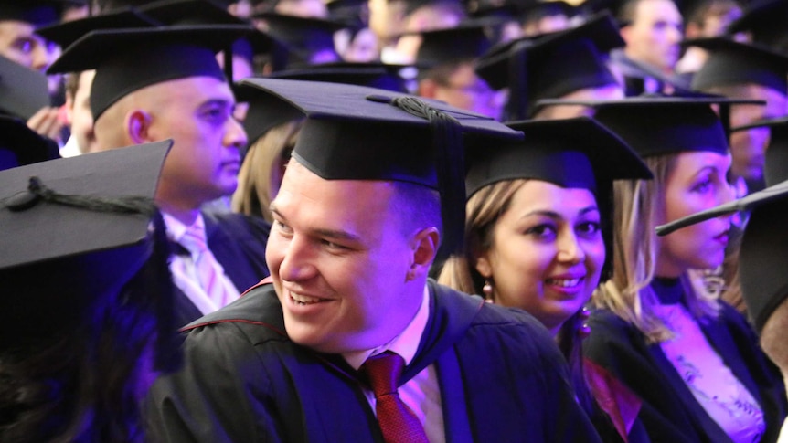 University graduates sit in rows at a graduation ceremony at the University of South Australia.
