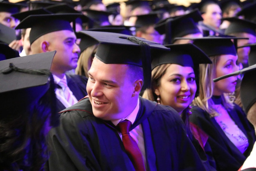 University graduates sit in rows at a graduation ceremony at the University of South Australia.