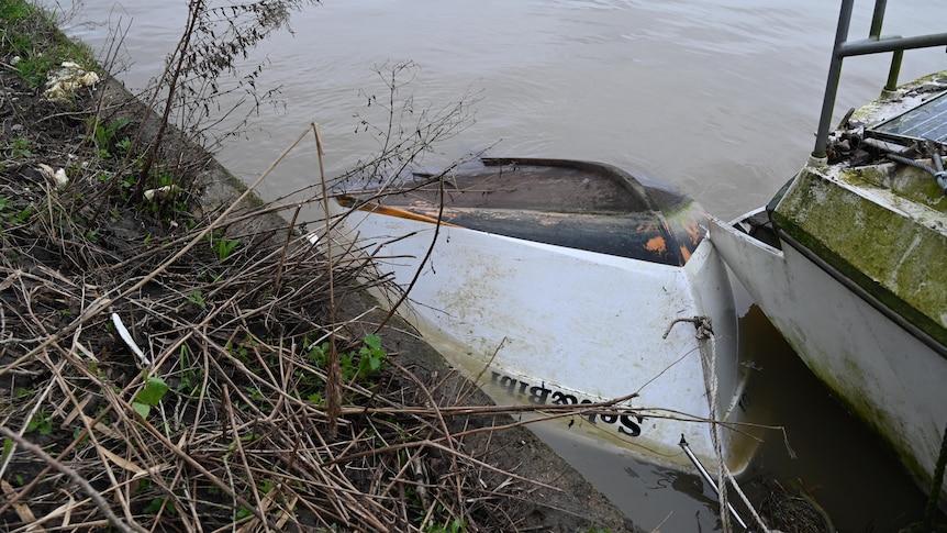 A small capsized boat in the water.