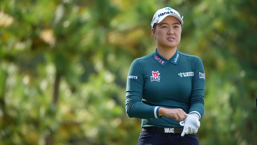 Australian golfer Min Jee Lee pulls on a glove as she looks down the fairway during a tournament.