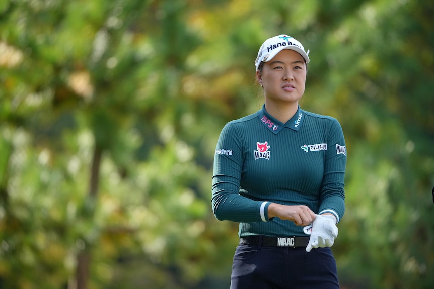 Australian golfer Min Jee Lee pulls on a glove as she looks down the fairway during a tournament.