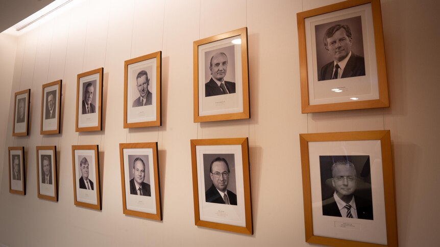 Black and white photos of men line the walls