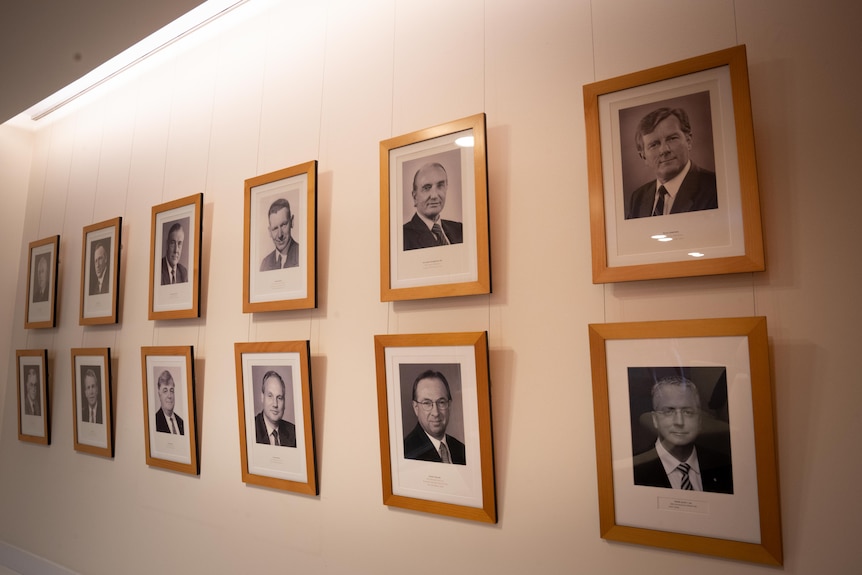 Black and white photos of men line the walls
