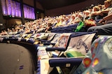 A large theatre filled with QCWA members and quilted branch banners