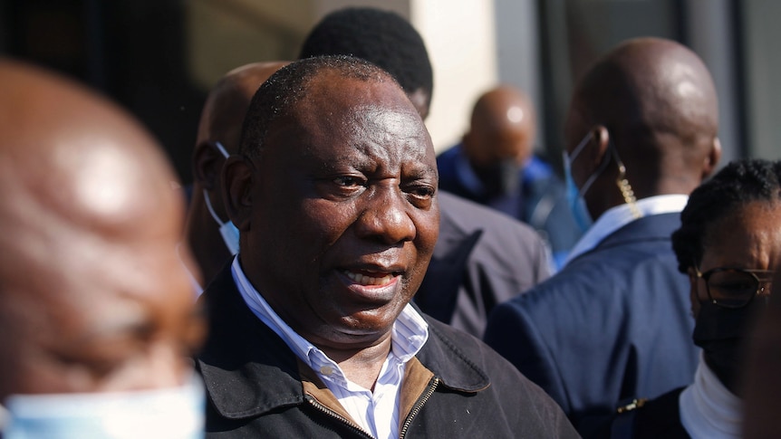 South African President Cyril Ramaphosa speaks to the media while visiting a shopping centre which was damaged