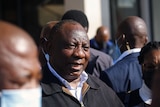 South African President Cyril Ramaphosa speaks to the media while visiting a shopping centre which was damaged