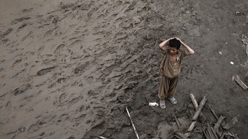 A boy stands in the mud