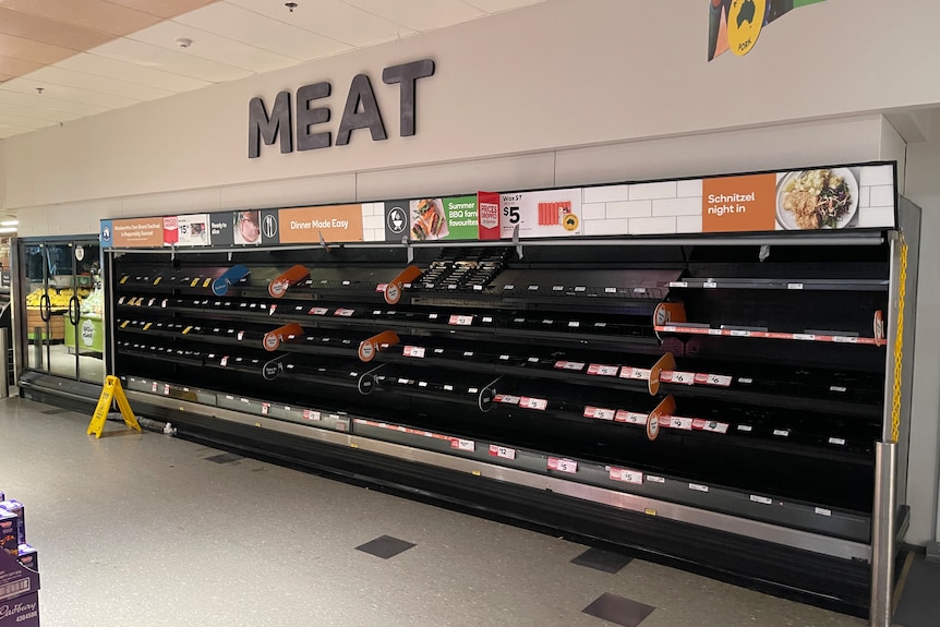 Empty supermarket area with meat written on the wall.